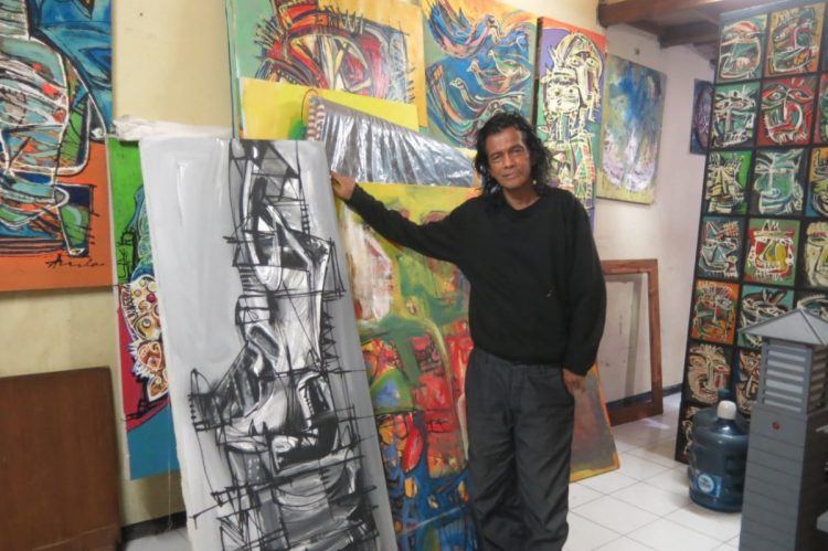 Pelukis Sidoarjo, Amdo Berada (59 tahun) produktif menghasilkan lukisan setiap hari. Dia merupakan seniman penghuni pertama Kampung Seni Pondok Mutiara Sidoarjo/Foto: Satria Nugraha