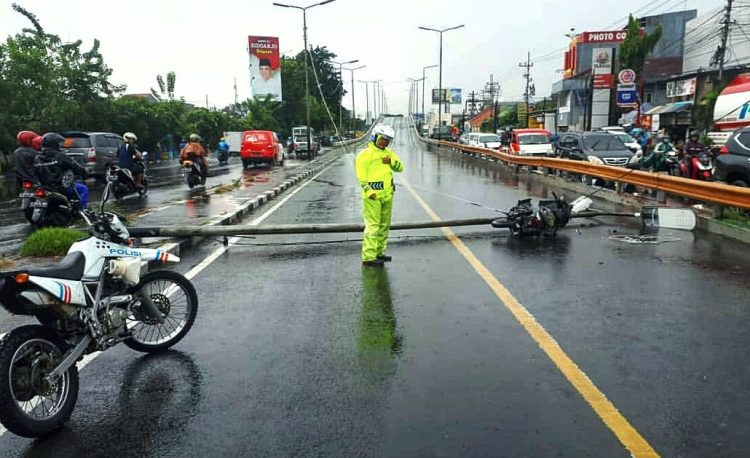 Seorang pengendara motor tertimpa tiang penerangan jalan umum (PJU di jalan waru, tepatnya di flyover Waru ketika hujan turun disertai angin kencang, Rabu (8/4/2020) siang/Foto: Ardian