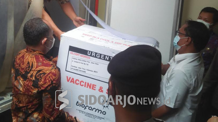 Petugas menurunan box berisi vaksin covid-19 yang tiba di Dinkes Sidoarjo