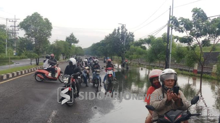 Pengendara motor putar balik setelah akses jalan Raya Tanggulangin-Porong ditutup polisi karena banjir. Sebagian dari mereka ada yang nekat melewati tanggul lumpur.