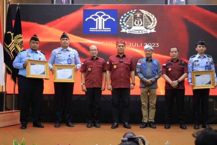 Tiga petugas Imigrasi Ponorogo saat menerima penghargaan dari Dirjen Imigrasi / Foto : Humas Kemenkumham