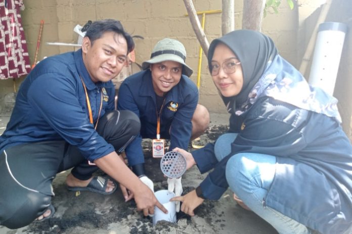 Mahasiswa KKN Unipa Surabaya saat memasuki biopori ke dalam tanah untuk resapan air dan mengolah sampah organik menjadi kompos di Desa Jatikalang Kecamatan Prambon, Sidoarjo / Foto: Ipung Syaiful