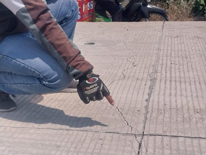 Warga saat menunjuk hamparan beton ruas jalan Krembung-Mojoruntut mengalami retak-retak/Foto: Ipung Syaiful