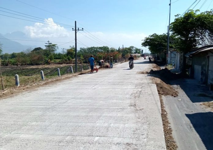 FOTO: Pekerja saat memasang topping urusan di kanan kiri beton ruas jalan Krembung-Mojoruntut Sidoarjo/Foto: Ipung Syaiful