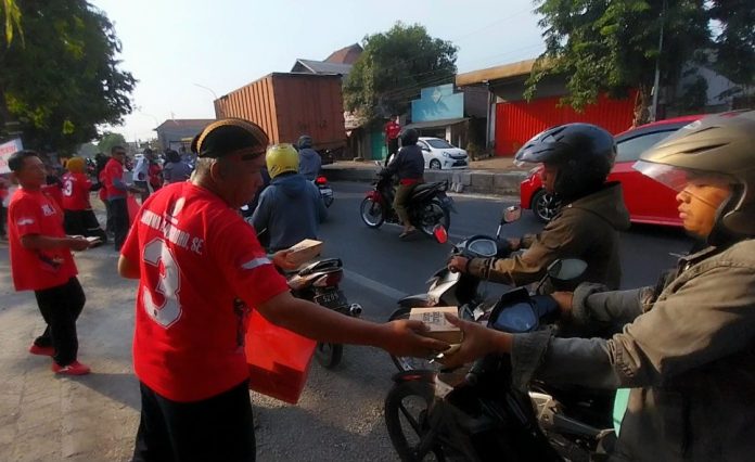 Komunitas Sego Anget saat membagikan ribuan nasi kota ke pengendara jalan di Balongbendo Sidoarjo/Foto: ipung Syaiful