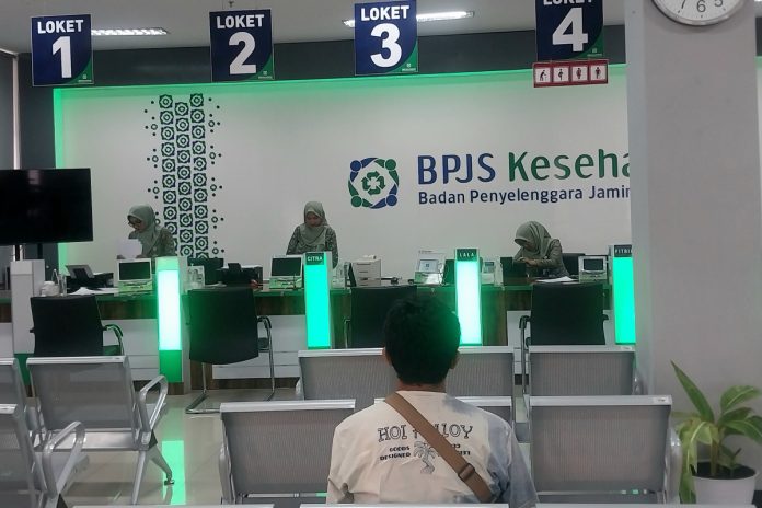 FOTO: Seorang peserta BPJS Kesehatan sedang menunggu antrian di loket layanan BPJS Kesehatan Cabang Sidoarjo/Foto: Ipung Syaiful