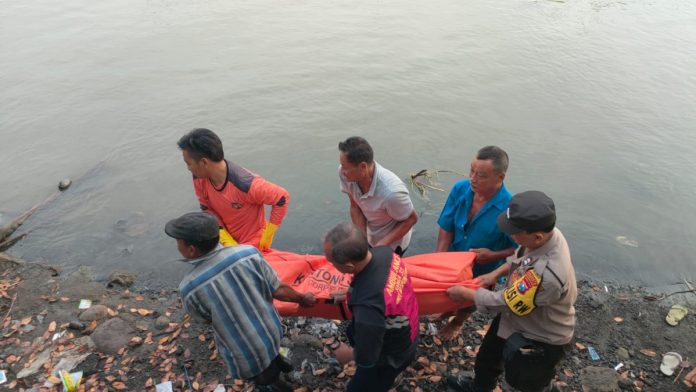 FOTO: Petugas Saat Mengevakuasi Jasad Korban dari Tepi Sungai. (Istimewa)