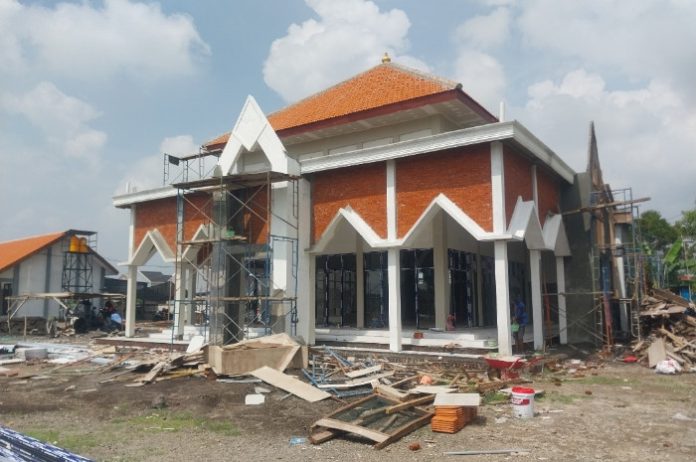 FOTO: Pekerja terlihat sedang mengerjakan bagian gedung ruang kelas dan masjid SMPN 2 Tulangan yang belum selesai dikerjakan/Foto: Ipung Syaiful