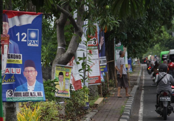 Sejumlah caleg yang memasang APK dengan cara memaku di pohon di pertigaan Jalan Pagerwojo, Buduran, Sidoarjo/Foto; Ipung Syaiful
