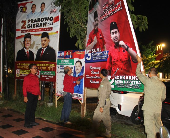 FOTO: Tim Gabungan dari Bawaslu Sidoarjo, Satpol PP dan Kepolisian saat menertibkan APK yang langgar aturan/Foto: Ipung Syaiful