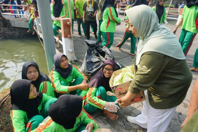 FOTO: Hj Fitrotin Hasanah Putri KH Hasyim Latif saat bersama siswa YPM membersihkan sungai di daerah sepanjang Taman/Foto: Istimewa