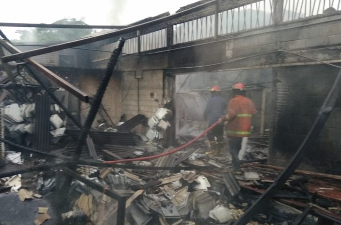 Petugas PMK sedang memadamkan api di tempat usaha coating di Jemundo, Taman Sidoarjo/Foto: BPBD Sidoarjo