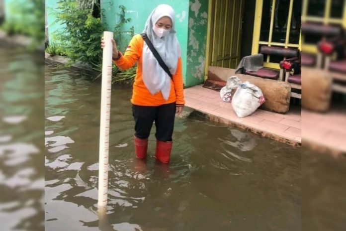 FOTO: Petugas saat melakukan pengukuran ketinggian genangan banjir di jalan Mawar Dusun Sambirono Wetan, Desa Sidodadi, Kecamatan Taman Sidoarjo/Foto: Istimewa