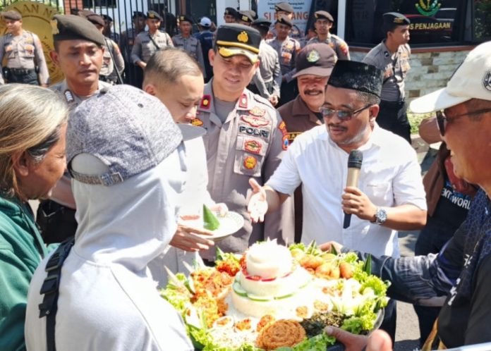 Puluhan Warga Desa Trosobo saat aksi damai dan potong tumpeng di depan Kantor Kejari Sidoarjo sebagai bentuk dukungan usut tuntas dugaan pungli PTSL di Trosobo/Foto: Ipung Syaiful