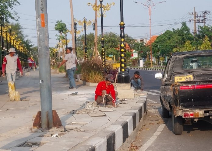 Sejumlah pekerja terlihat membenahi granit dan instalasi kabel trotoar GOR Sidoarjo/Ipung Syaiful