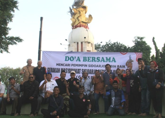 Puluhan elemen masyarakat saat doa bersama dan diskusi cari pemimpin Sidoarjo yang lebih baik di Monumen Jayandaru Alun-Alun Sidoarjo pada Selasa (30/7/2024)/Foto: Ipung Syaiful