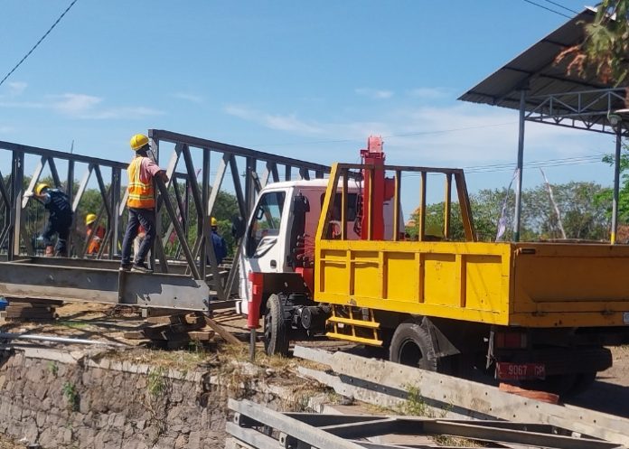 Sejumlah pekerja saat memasang bagian jembatan Bailey di Kedungpeluk/Foto: Ipung Syaiful