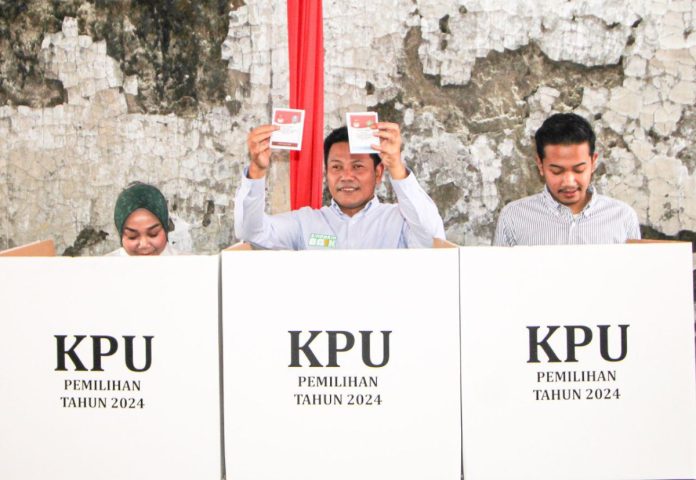 Calon Bupati Sidoarjo, Subandi, (tengah) bersama keluarga menyalurkan hak suaranya di TPS 2 Desa Pabean, Kecamatan Sedati.