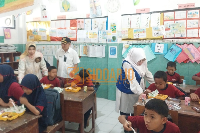 Sekda Fenny Apridawati bersama DPC IWAPI Sidoarjo saat melihat siswa SDN Kedungpandan 1, Kecamatan Jabon menikmati makan bergizi gratis/Foto: Ipung Syaiful