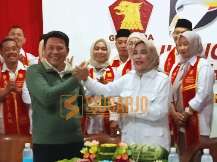 Ketua DPC Gerindra Sidoarjo, Mimik Idayana, saat memberikan potongan tumpeng pertama kepada Plt Bupati Sidoarjo, Subandi, yang sekaligus Bupati Sidoarjo terpilih dalam momen HUT ke-17 Partai Gerindra di kantornya Jalan Lingkar Barat, Magersari, Buduran, Sidoarjo /Foto: Ipung Syaiful