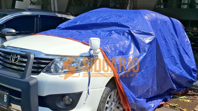 Salah satu mobil yang terkena dampak pohon tumbang ketika parkir di area T2 Bandara Juanda/Foto: Hnf