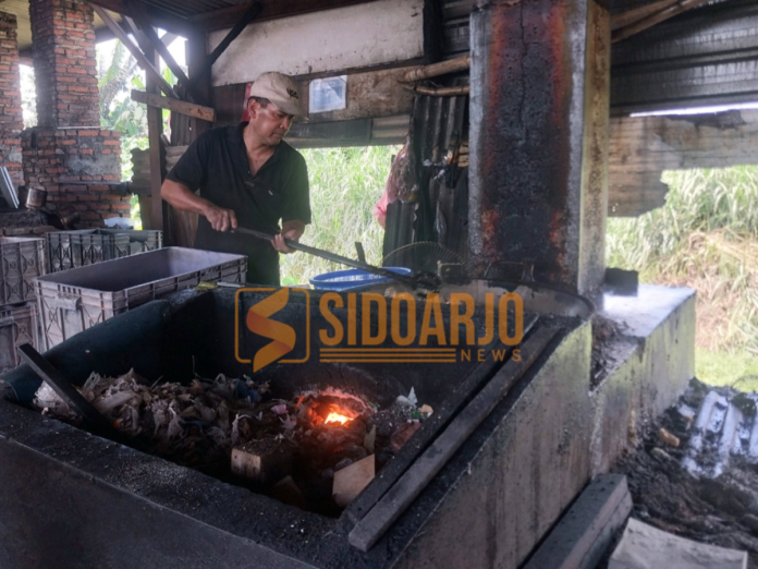 Salah satu pekerja menggoreng tahu dari bahan bakar sampah di Tropodo, Kecamatan Krian, Sidoarjo / Foto: Ipung Syaiful