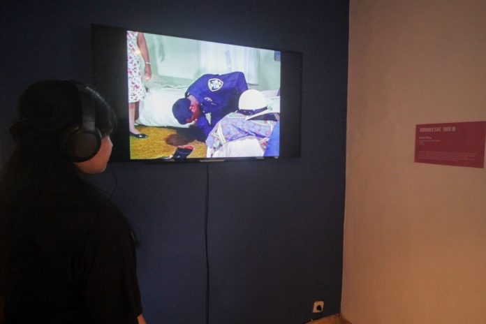 Salah satu pengunjung pameran sedang melihat karya dengan tema besar mengenai dunia digital dan bagian awal dari pameran ini berfokus pada sejarah panjang internet / Foto: sidoarjonews.id