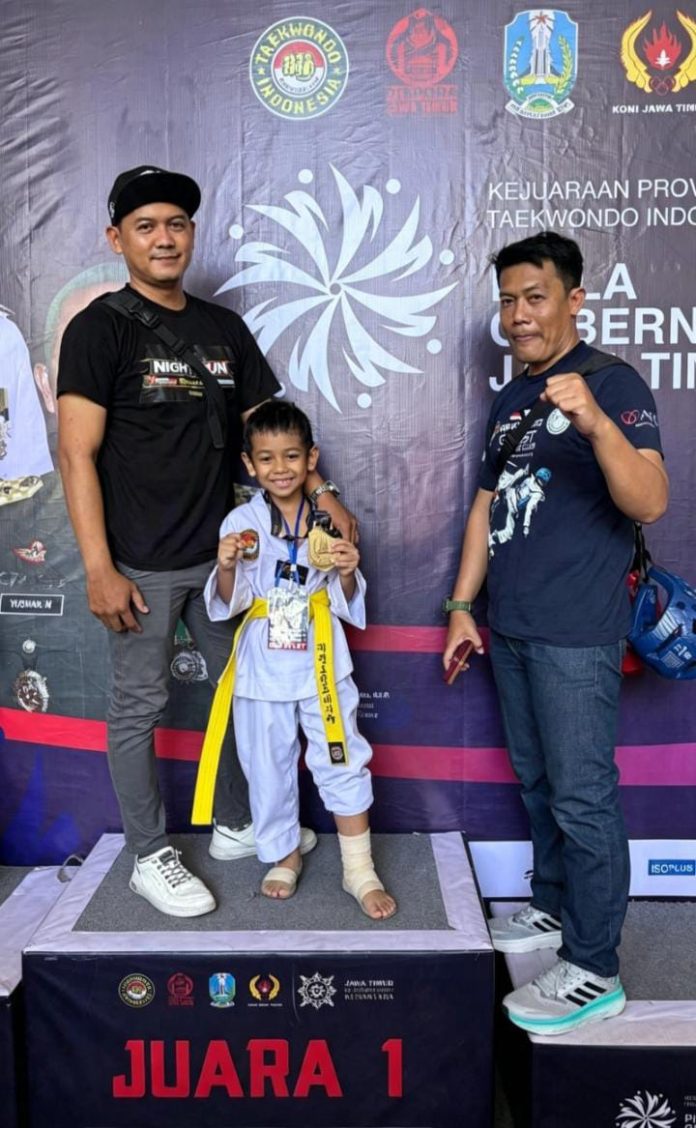Sagara, peraih medali emas kategori 20 kilogram kelas TK B, didampingi dua pelatihnya, Hartono dan Khohar Efendy, dari Ghost Fighter Sidoarjo usai menjuarai event Kejuaraan Provinsi Taekwondo Indonesia Piala Gubernur Jatim Antarpelajar 2026 di Gor Kranjengan Park, Surabaya, 27 hingga 30 Agustus 2026 / Foto: istimewa